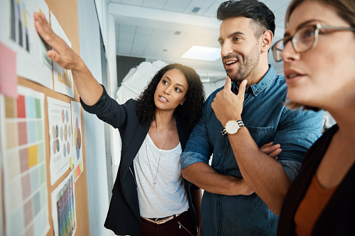A diverse team collaborating around a board with charts and ideas