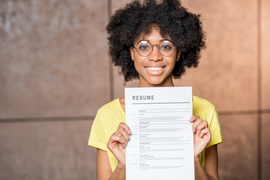 A student holding a professional résumé